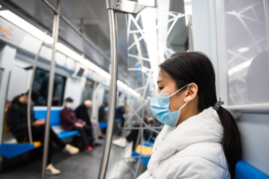 在地铁上戴口罩的年轻女人