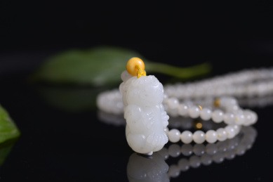 黑色背景上的和田玉吊坠，龙雕件