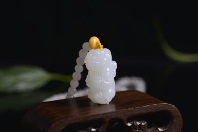 黑色背景上的和田玉吊坠，龙雕件