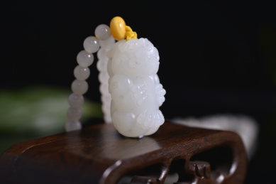 黑色背景上的和田玉吊坠，龙雕件