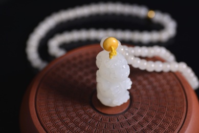 黑色背景上的和田玉吊坠，龙雕件