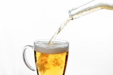 向杯中倒啤酒特写白色背景