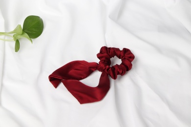 白色背景布上面的酒红色发饰与绿叶