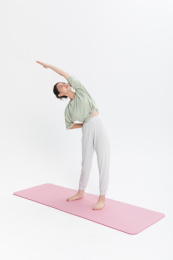 站在瑜伽垫上拉伸身体的居家女性