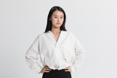 穿着白衬衫的职场女性双手叉腰