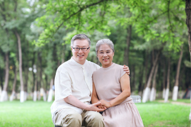 幸福的老年夫妇坐在户外公园的椅子上