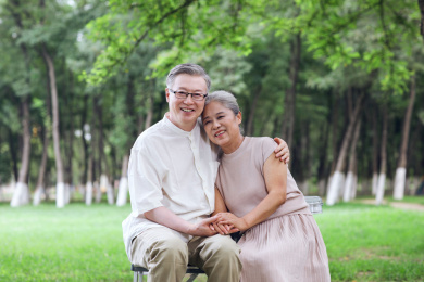 幸福的老年夫妇坐在户外公园的椅子上