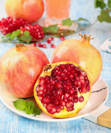 浅蓝底上放着一盘云南蒙自石榴