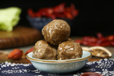 深色背景上碗中放着牛肉丸