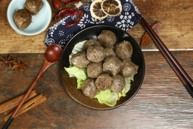 深色背景上盘里放着牛肉丸