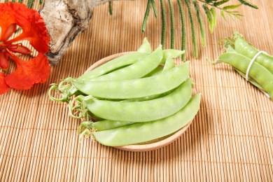 放在木盘中的带壳新鲜豌豆