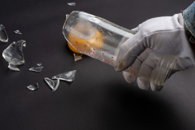 男子清洁破烂的玻璃奶瓶