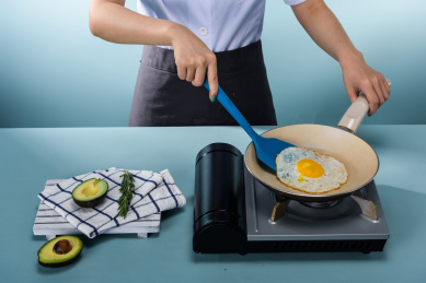 蓝色的铲勺煎鸡蛋蓝色背景