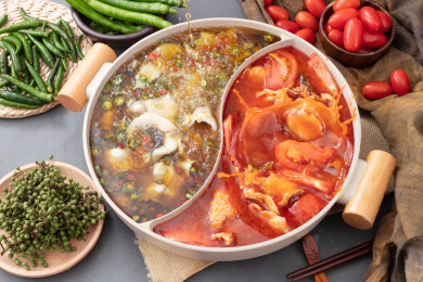 桌子上沸腾的青椒鱼番茄鱼双拼鸳鸯火锅