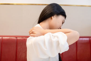 室内一名肩膀疼痛的年轻女性