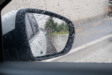 沾满雨滴的车窗玻璃和汽车后视镜
