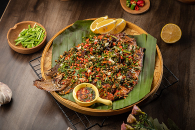 棕色桌面上放着一盘香茅草烤鱼