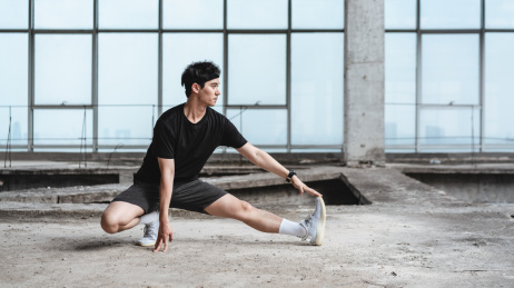 年轻运动男子在做拉伸动作