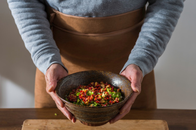 双手捧起盛放有青红辣椒酱的日式陶瓷大碗