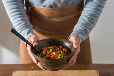 双手捧起盛放有青红辣椒酱的日式陶瓷大碗