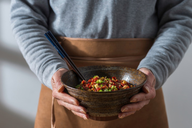 双手捧起盛放有青红辣椒酱的日式陶瓷大碗