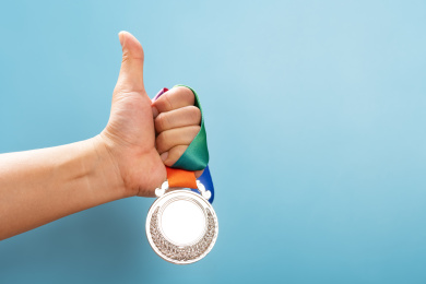 男人拿着银牌竖着大拇指