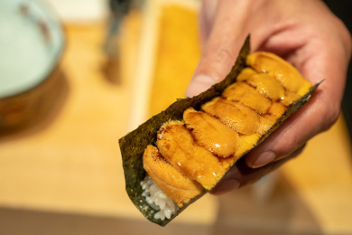 手拿一份做好的海胆海苔寿司