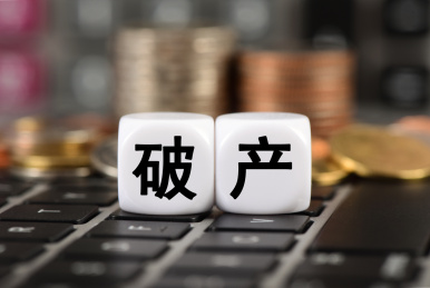 笔记本电脑上计算器和硬币前的文字破产