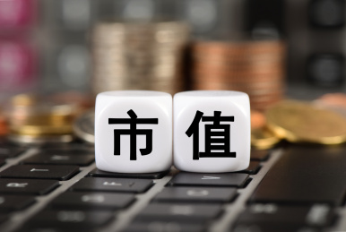 笔记本电脑上计算器和硬币前的文字市值