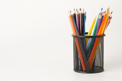 白色背景下的笔筒里放着一堆彩铅