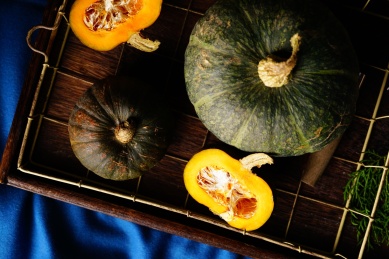 多种南瓜放置在蓝色的桌布上