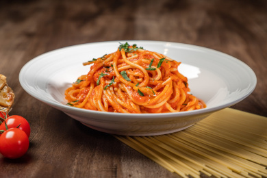棕色木纹桌上放着一盘意大利面