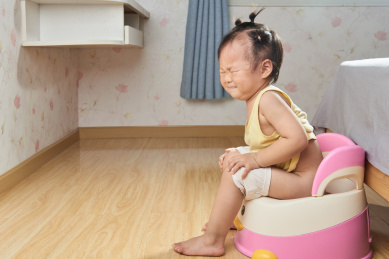 便秘的幼儿在座便器上用力排便