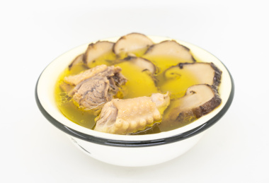 白色背景瓷碗里乘的松茸炖鸡汤