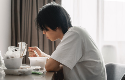 男子坐在桌子旁吃外卖