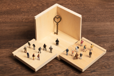 微缩创意人群围着打开的盒子里的古老钥匙