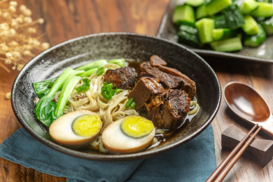 排骨卤蛋面摆放在木桌面上旁边放有拌黄瓜