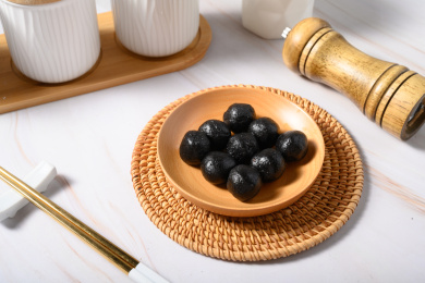 桌面上的盘子里的黑乎乎的芝麻丸