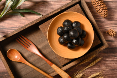 桌面上的盘子里的黑乎乎的芝麻丸