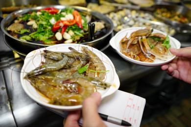 手拿白盘装潮汕美食生腌虾和蟹