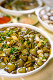 白盘装潮汕美食生腌沙蚬放桌子上