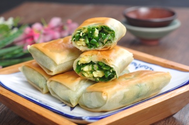 木桌上的一盘韭菜鸡蛋馅素锅贴