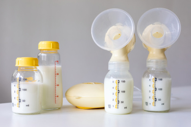桌面上的吸奶器和装满了母乳的奶瓶
