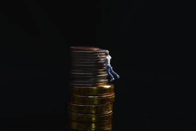 攀登金钱黑色背景下的小人与钱币