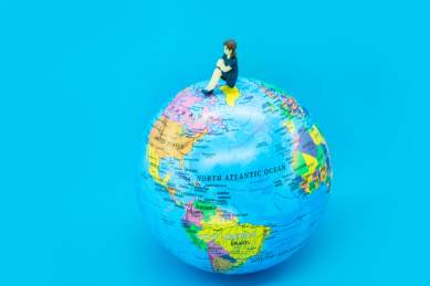 创意图片地球仪上坐着的小女孩