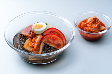 一碗朝鲜冷面和辣白菜放在白色背景上