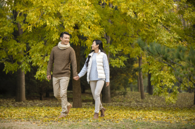 快乐的年轻情侣在树林散步