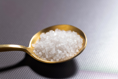 一勺食盐摆放在灰色背景上特写
