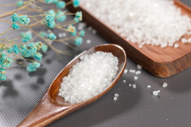 一勺食盐摆放在灰色背景上特写