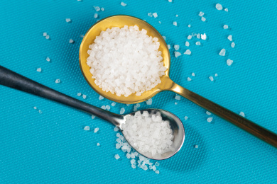 一勺食盐摆放在蓝色背景上特写